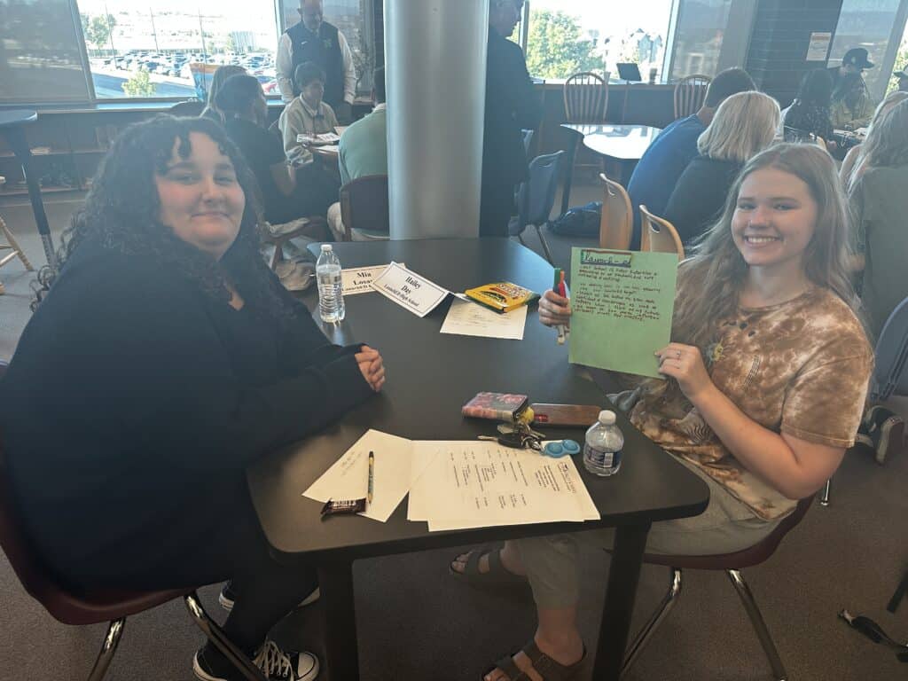 Image of two high school students holding up a sign between then that says LaunchED.